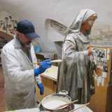 In fondo ci attende il cuore pulsante del luogo: il laboratorio, dove troviamo Claudio Riso con indosso un camice bianco, un capellino azzurro e dei guanti in lattice intento a terminare una statua della Madonna